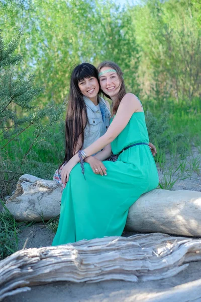Zwei junge Frauen sitzen auf Gras und amüsieren sich — Stockfoto