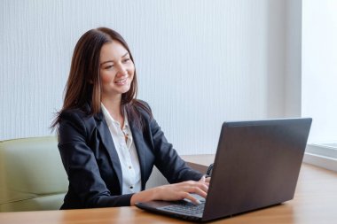 çekici bir kadın ofis dizüstü bilgisayar üzerinde çalışan