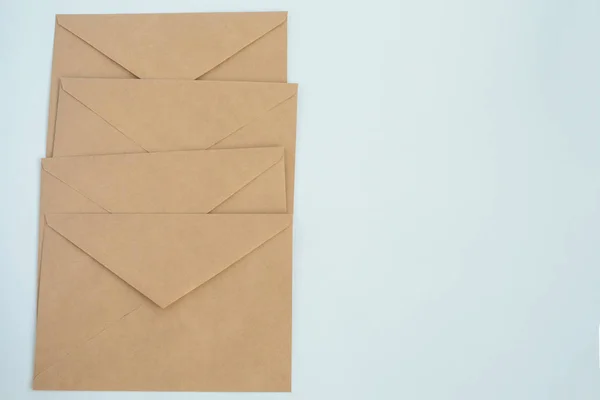 Several envelopes from brown letter paper, on white background close-up, top view — Stock Photo, Image