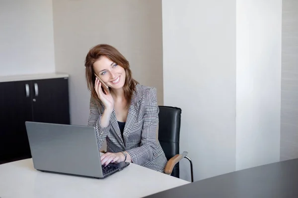 A fiatal üzletasszony, telefon, laptop számítógép előtt portréja — Stock Fotó