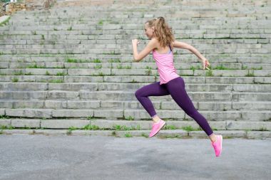 Fotokopi alanı konsepti spor sporu sağlık sağlık sağlığı zayıflama kardiyo antrenmanı sağlık koşusu sağlığıyla aktif koşan genç bayan sporcu yan görünümü.