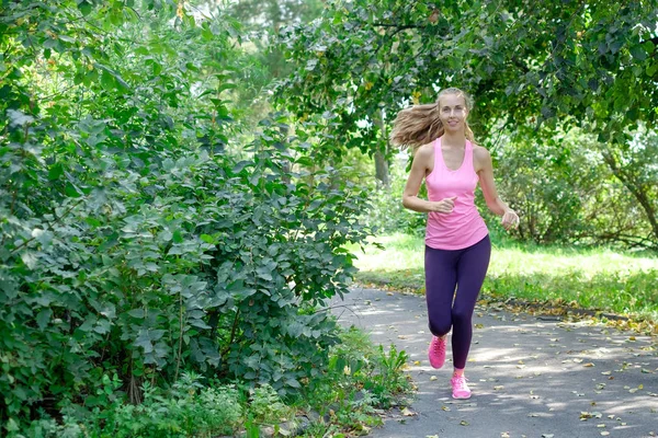 Hermosa joven corriendo en el parque verde en el soleado día de verano —  Fotos de Stock