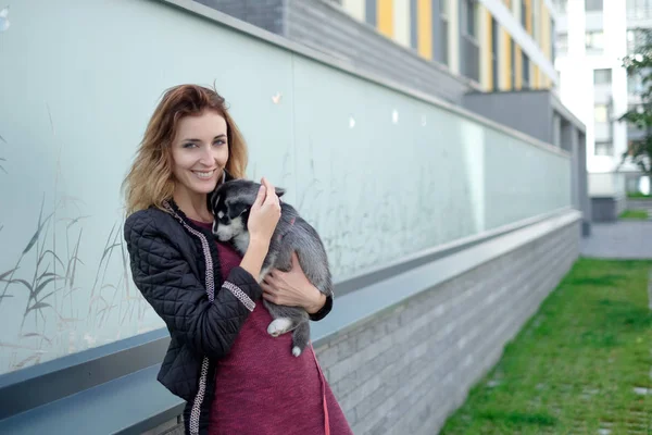 Улыбающаяся женщина держит милого щенка — стоковое фото