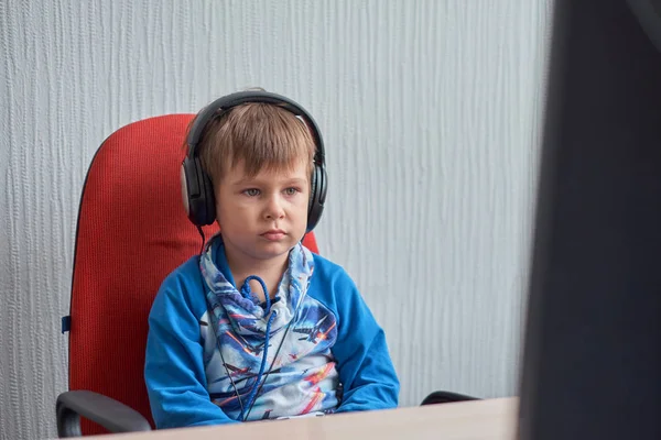Vrije tijd, onderwijs, kinderen, technologie en mensen concept - jongen met computer en koptelefoon op kantoor — Stockfoto