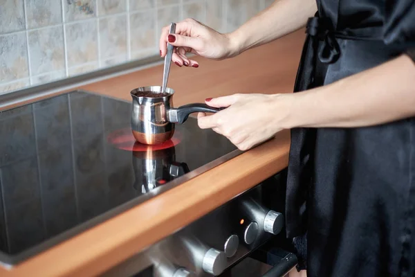Una foto de una joven preparando café en la cocina por la mañana —  Fotos de Stock