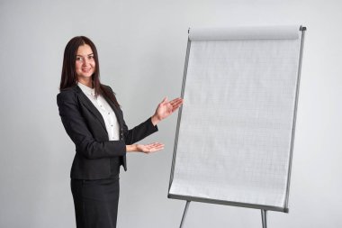 flipchart Office tarafından duran genç gülümseyen iş kadını portresi