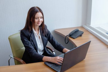 Dizüstü bilgisayar ofiste çalışan genç asistanı