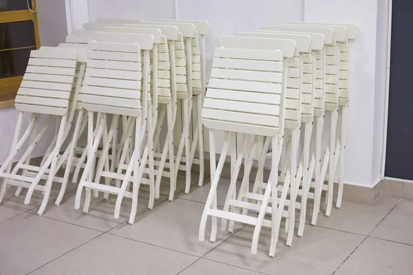stacks of white folding chairs in office