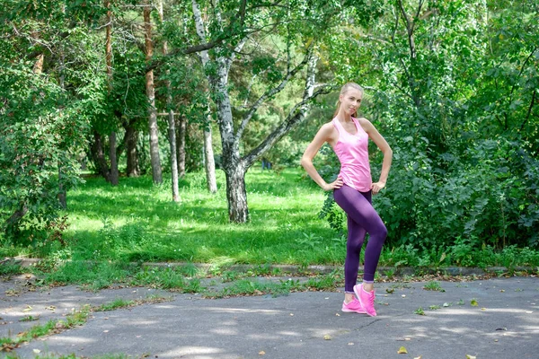 Corredor femenino con hermosa figura haciendo ejercicio de estiramiento —  Fotos de Stock