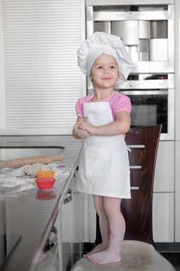 Mutfak pişirme küçük kız. Kek ve kurabiye yaparken eğleniyor.