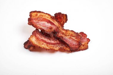Three cooked, crispy fried bacon isolated on a white background. clipart
