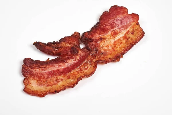 Tre kokta, knaprigt stekt bacon isolerad på en vit bakgrund. — Stockfoto