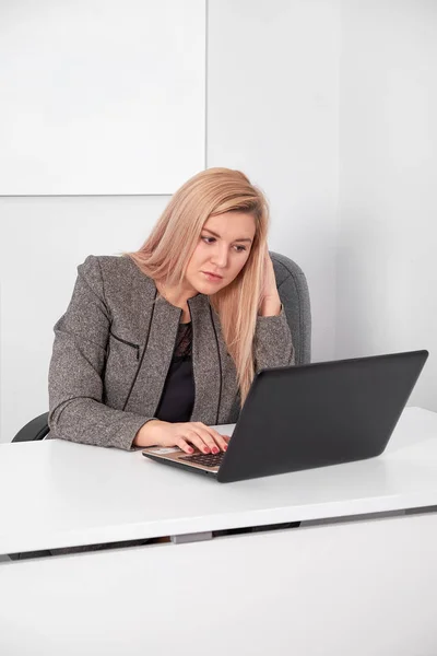 Schöne Geschäftsfrau arbeitet hinter Laptop im Büro — Stockfoto