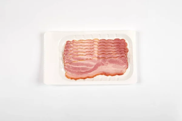 Bacon skivor på förpackningen, isolerad på vit bakgrund — Stockfoto