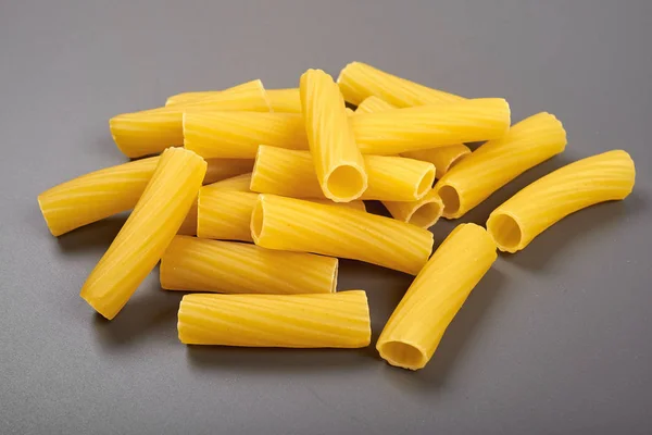 Italiaanse pasta rigatoni geïsoleerd op een grijze achtergrond — Stockfoto