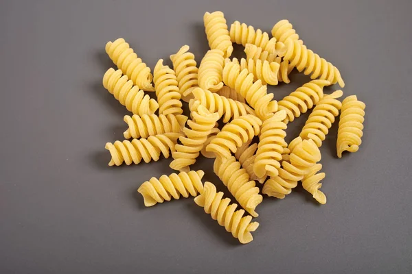 Nouilles de pâtes fusilli non cuites isolées sur fond gris — Photo