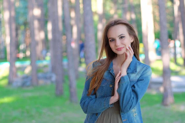 Kvinnan ler med perfekt leende i en park och tittar på kameran — Stockfoto
