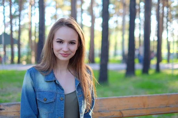 Mujer sonriendo con una sonrisa perfecta en un parque y mirando a la cámara — Foto de Stock