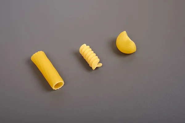 Olika typer av pasta isolerad på grå — Stockfoto