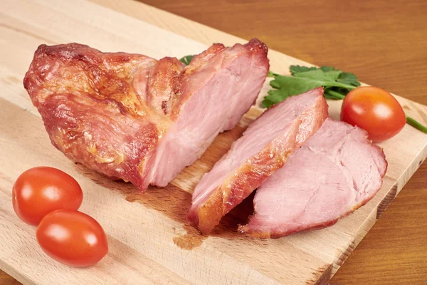 Carne asada de cerdo cocida en rodajas sobre tabla de cortar de madera . — Foto de Stock