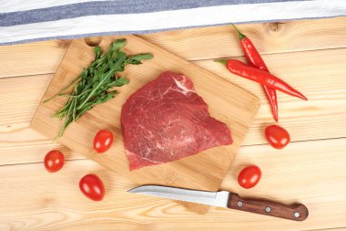 Kesme tahtası üzerinde ham sığır etli sebze ahşap arka plan üzerinde