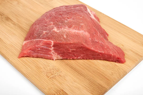 Carne fresca em bruto numa tábua de corte isolada sobre fundo branco — Fotografia de Stock