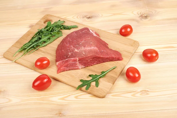 Kesme tahtası üzerinde ham sığır etli sebze ahşap arka plan üzerinde