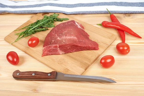 Kesme tahtası üzerinde ham sığır etli sebze ahşap arka plan üzerinde