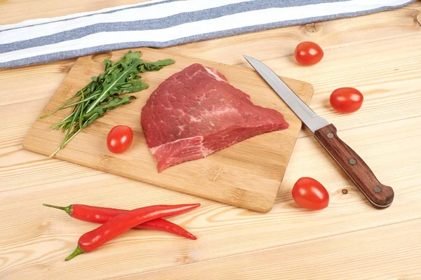木製の背景に野菜をまな板の上生牛肉 — ストック写真