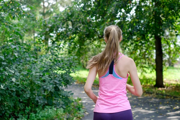 Attraente giovane donna che fa jogging sul sentiero del parco. concetto di stile di vita sano — Foto Stock