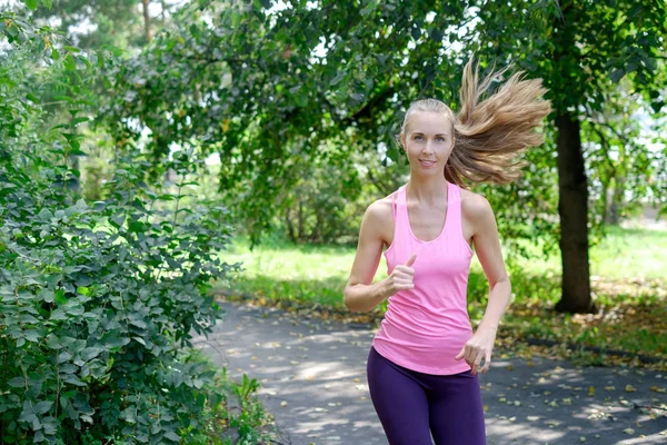 Attraente giovane donna che fa jogging sul sentiero del parco. concetto di stile di vita sano — Foto Stock