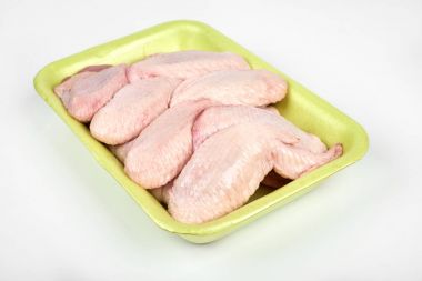 Beyaz arka plan üzerinde izole çiğ tavuk kanatları paketi