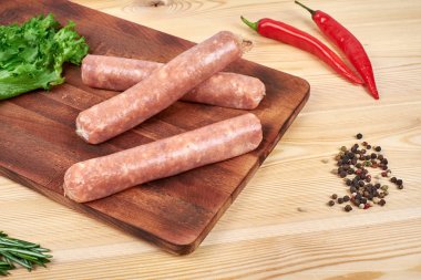 Sebze ve baharat ahşap arka plan üzerinde çiğ sosis