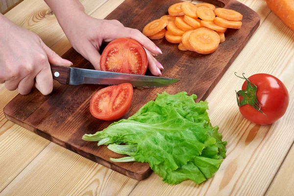 Nahaufnahme von weiblichen Hand Schneiden von Tomaten auf Schneidebrett zu Hause, Kochen, Essen und Home-Konzept — Stockfoto