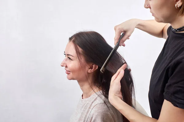 Estilista haciendo nuevo corte de pelo a la mujer morena en el salón — Foto de Stock