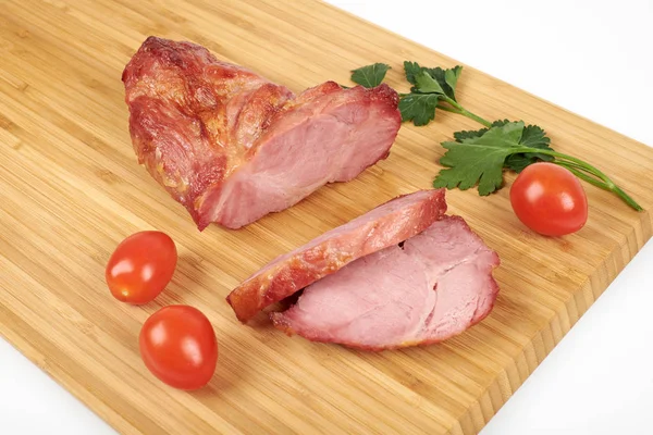 Carne asada de cerdo cocida en rodajas sobre tabla de cortar de madera sobre fondo blanco — Foto de Stock