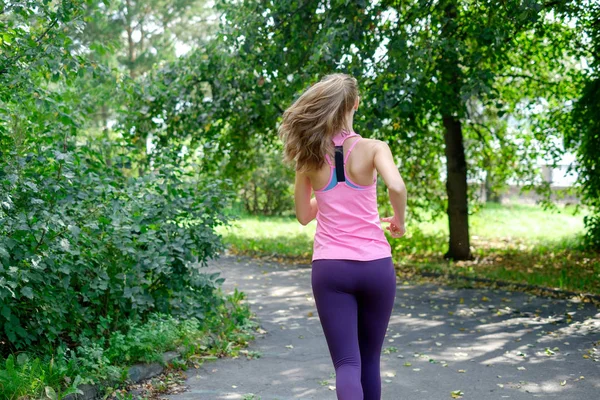 Jolie jeune femme jogging sur le sentier du parc. concept de mode de vie sain — Photo