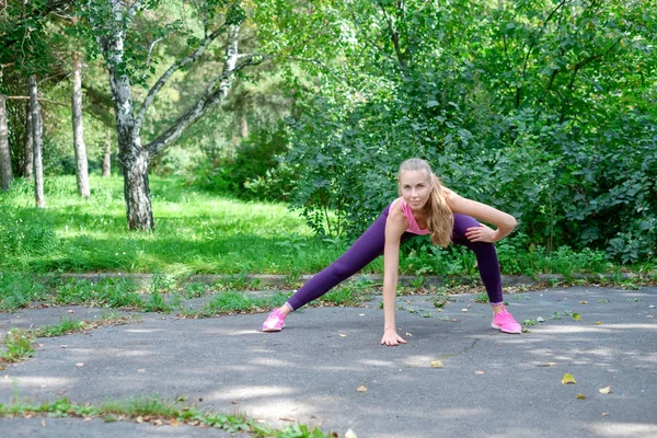 Female runner with beautiful figure doing stretching exercise — Stock Photo, Image