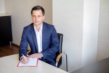 Notlar yapacak meşgul erkek ofis çalışanı