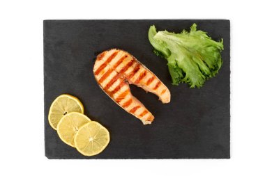 Limon ve kayrak salataya kızarmış som balığı biftek. Beyaz arka plan üzerinde izole