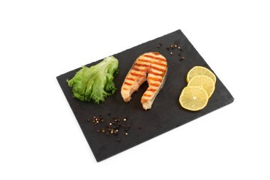 Limon ve kayrak salataya kızarmış som balığı biftek. Beyaz arka plan üzerinde izole