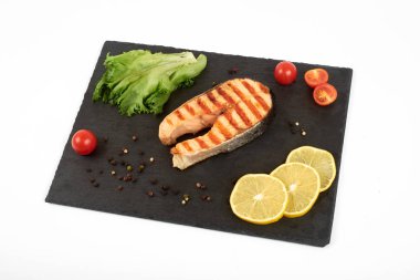 Limon ve kayrak salataya kızarmış som balığı biftek. Beyaz arka plan üzerinde izole