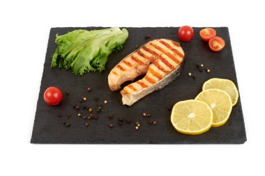 Limon ve kayrak salataya kızarmış som balığı biftek. Beyaz arka plan üzerinde izole