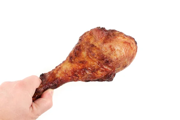 Zbliżenie i odosobniony obraz dłoni trzymającej grillowaną nogę kurczaka na białym tle. — Zdjęcie stockowe