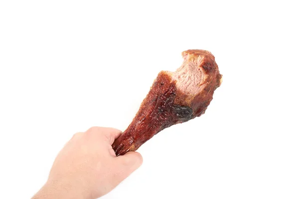 Hand holding roasted turkey leg with bite taken , isolated on white background. — Stock Photo, Image