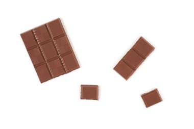 Beyaz arka planda izole edilmiş koyu sütlü çikolata parçaları..