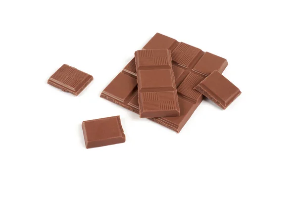 Pedaços de barra de chocolate de leite escuro isolado no fundo branco . — Fotografia de Stock