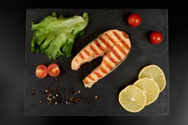 Limonlu ızgara somon bifteği, domates ve salata..