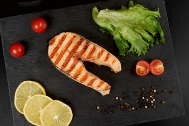 Limonlu ızgara somon bifteği, domates ve salata..