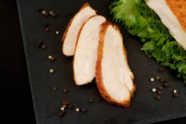 Izgara tavuk filetosu ve taş tabakta sebze.